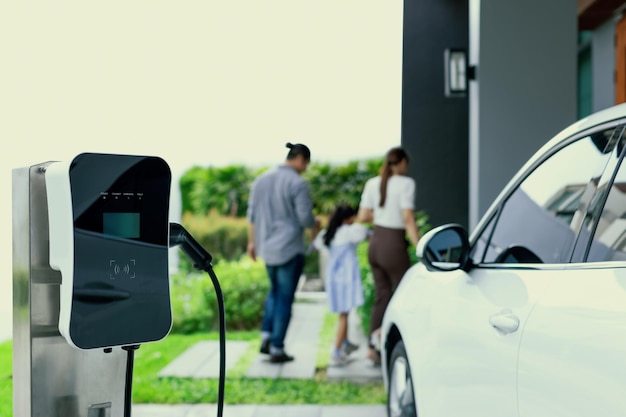 Station de charge domestique Focus pour la famille progressive de flou de voiture EV en arrière-plan