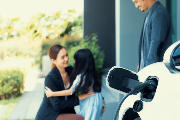 Station de charge domestique Focus pour la famille progressive de flou de voiture EV en arrière-plan