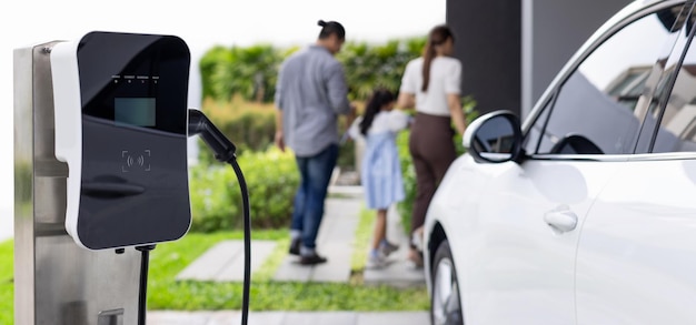 Station de charge domestique Focus pour la famille progressive de flou de voiture EV en arrière-plan