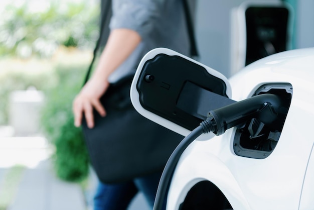 Station de charge Focus EV à la maison avec un homme progressif flou en arrière-plan