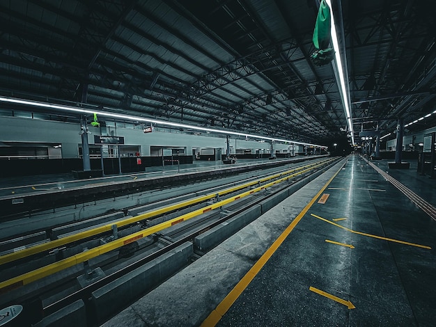 Une station de métro sombre et vide avec des lignes jaunes