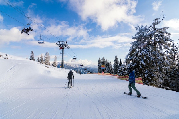 Station de ski dans la belle lumière du coucher du soleil Vue depuis les pistes de ski supérieures forêt de pins et montagnes en arrière-plan Vacances d'hiver à Bukovel Carpates Ukraine Europe