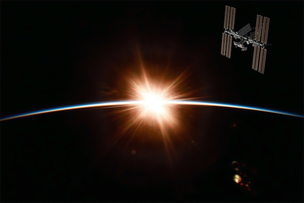 La Station spatiale internationale au-dessus de la planète Terre au lever du soleil à l'horizon. Éléments de cette image fournis par la NASA. rendu 3D.