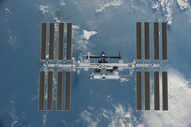 Station spatiale internationale sur l'orbite de la terre vue de la planète depuis l'espace extra-atmosphérique avec des nuages ...