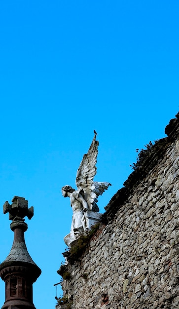 Une statue d'un ange ailé au sommet d'un immeuble.