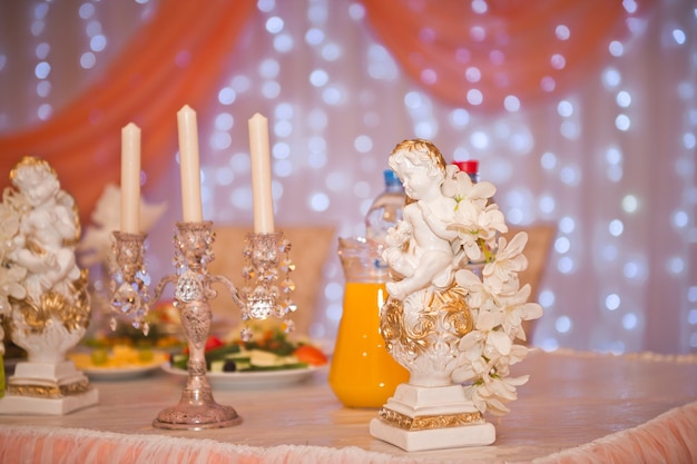 Une statue d'ange et un chandelier en argent pour décorer la table de mariage