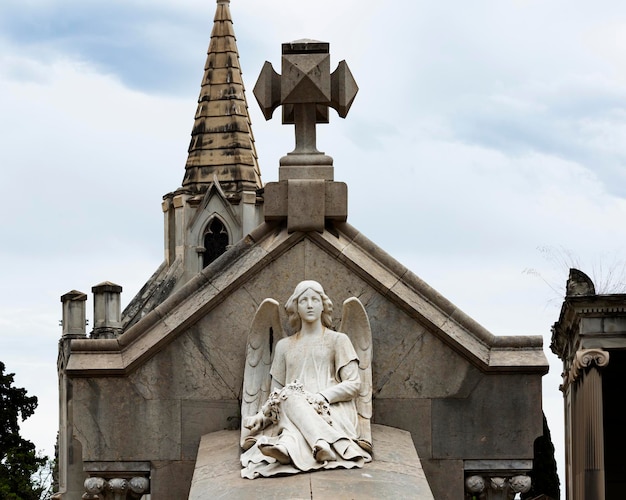 Photo une statue d'ange est assise sur une croix au sommet d'une église.