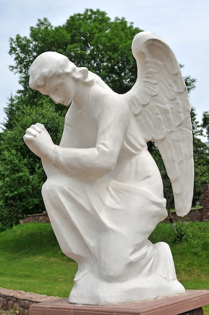 Statue d'un ange en prière dans le jardin.