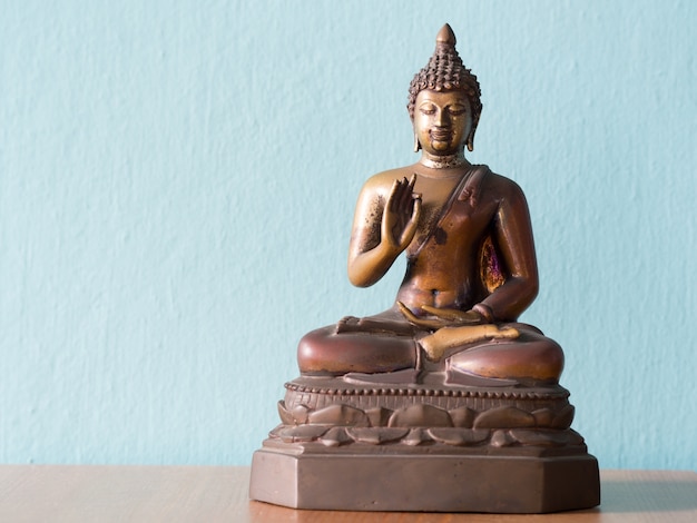 Statue antique de Bouddha sur une table en bois