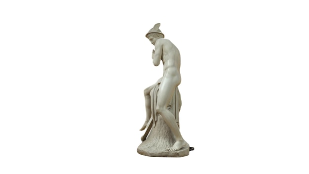 Une statue blanche d'une femme assise avec un chapeau sur la tête.