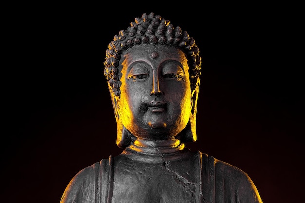 Statue de Bouddha avec lueur sur fond noir