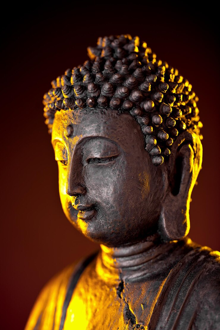Photo statue de bouddha avec lueur sur fond noir