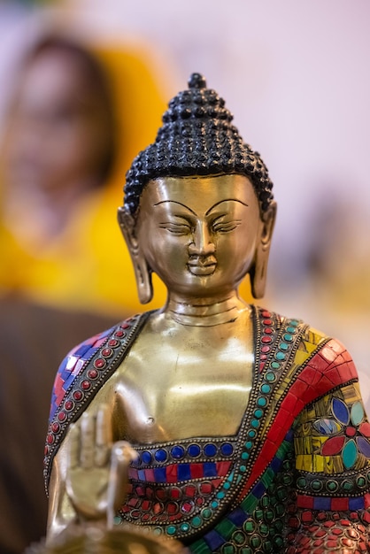 Une statue de Bouddha avec des motifs colorés sur le visage