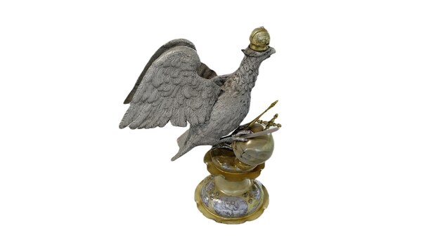 Une statue en bronze d'un oiseau debout avec une ampoule plaquée or sur sa tête.