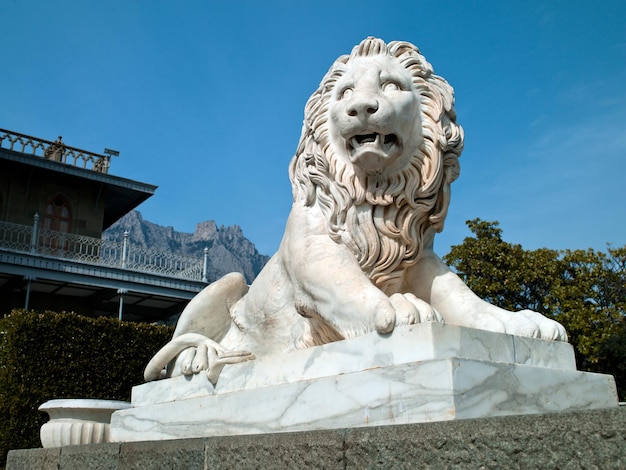 Statue concrète de photo d'un lion sur un fond blanc du ciel nuageux