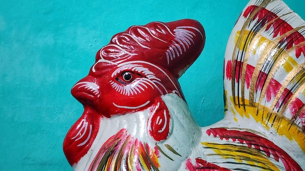 une statue de coq en céramique colorée est exposée