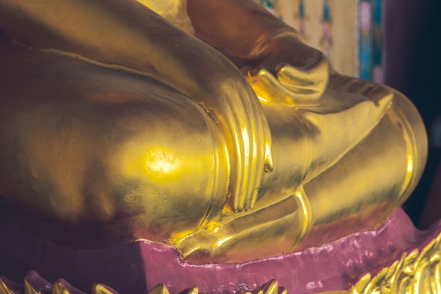 Statue dorée de Bouddha sur le piédestal avec de vieux murs