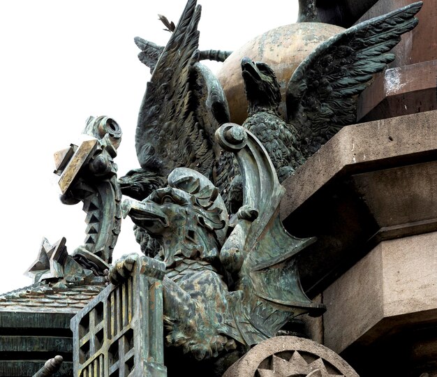 Une statue d'un dragon avec des ailes et un bouclier sur le dessus.