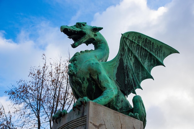 Photo statue de dragon sur le pont du dragon lors d'une journée ensoleillée à ljubljana, capitale de la slovénie