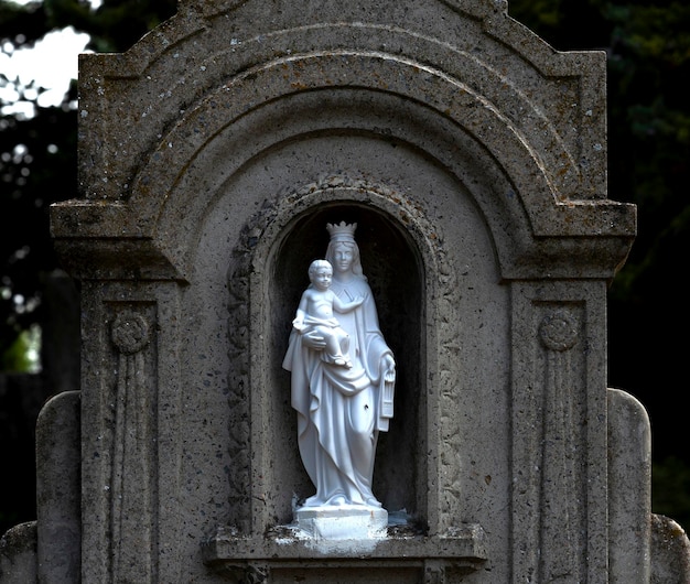 Photo une statue d'une femme et d'un enfant dans un cimetière.