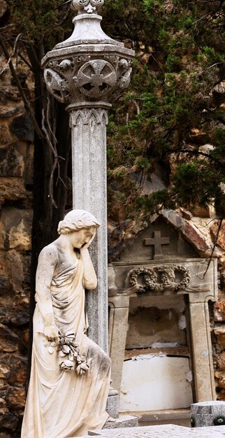 Photo une statue de femme se tient à côté d'un pilier avec une croix dessus.