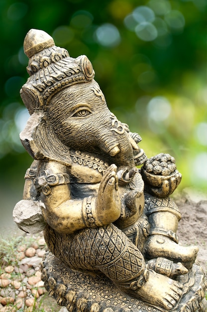 Une statue de Ganesha cassée sur fond vert