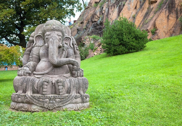 Statue de Ganesha, en pierre, avec un beau jardin de montagne en arrière-plan