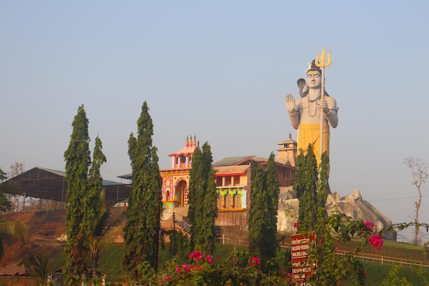 Une statue géante de Shiva s'élève au-dessus du paysage.