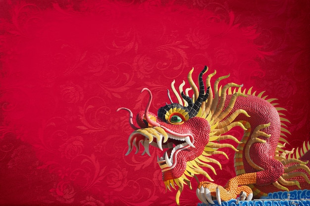 Statue de grand dragon rouge sur fond de texture rouge.