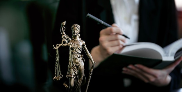 Statue de Lady Justice avocat tenant un livre en arrière-plan