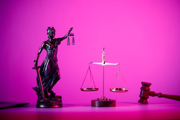 Statue de Lady Justice avec des écailles sur la table en néon violet.