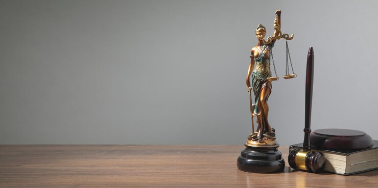 La statue de Lady Justice, le livre du marteau du juge sur la table.