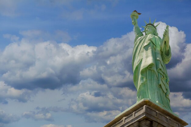 Photo la statue de la liberté sur liberty island, new york bleu ciel parfait de nuages