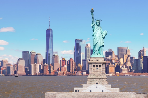 Photo la statue de la liberté avec le one world trade building center sur la rivière hudson et l'arrière-plan du paysage urbain de new york, monuments de lower manhattan new york city.