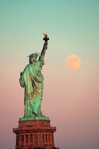 Statue de la liberté et pleine lune au coucher du soleil à New York