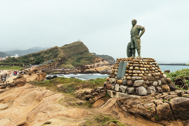 Statue de M. Lin Tien-Chen dans le géoparc de Yehliu, une cape sur la côte nord de Taïwan. Un paysage de rochers en nid d'abeilles et de champignons érodés par la mer.