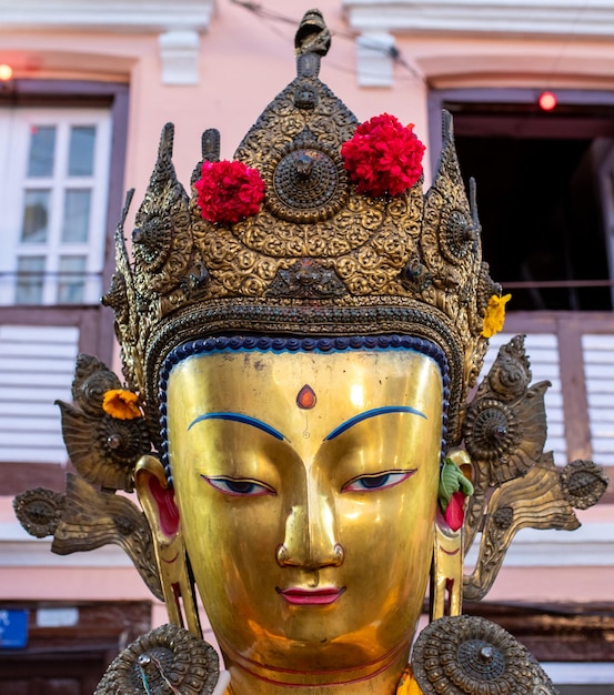 Photo une statue d'or avec des fleurs sur elle est à l'extérieur d'un bâtiment