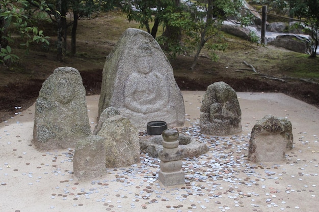 une statue en pierre avec une sculpture de Bouddha dessus