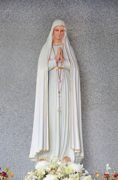 Photo statue de la vierge marie dans l'église catholique romaine sur fond de granit.