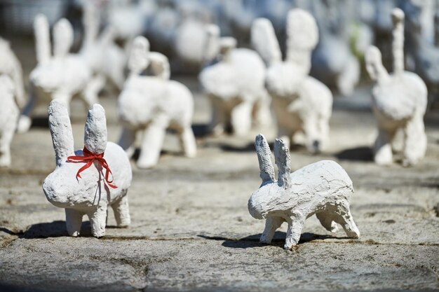 Statues de lapin blanc en plâtre à l'exposition d'art en plein air drôles de lièvres blancs dans la rue