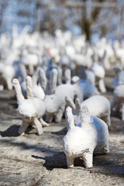 Statues de lapin blanc en plâtre à l'exposition d'art en plein air drôles de lièvres blancs dans la rue