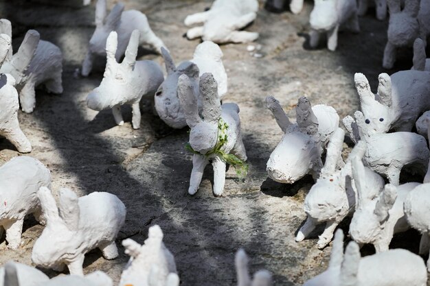 Statues de lapin blanc en plâtre à l'exposition d'art en plein air drôles de lièvres blancs dans la rue