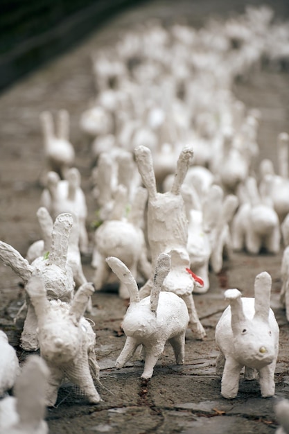 Statues de lapin blanc en plâtre à l'exposition d'art en plein air drôles de lièvres blancs dans la rue