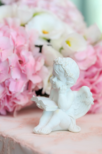 Statuette d'un ange doux blanc sur un floral.