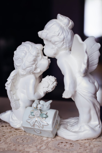 Statuette blanche de deux anges sur table. fermer. baiser.