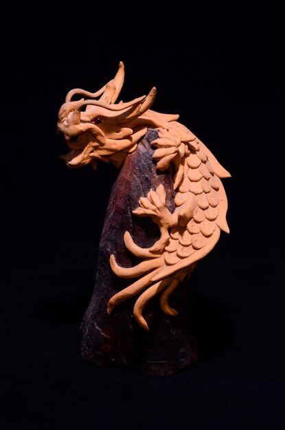 Photo statuette en bois faite à la main d'un dragon