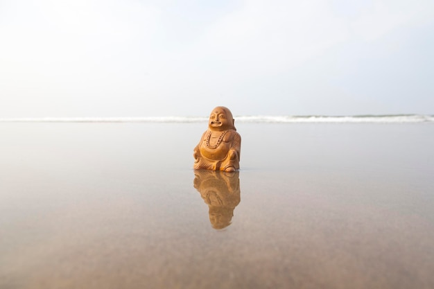 Statuette de Bouddha sur la plage Vagues bleues en arrière-plan