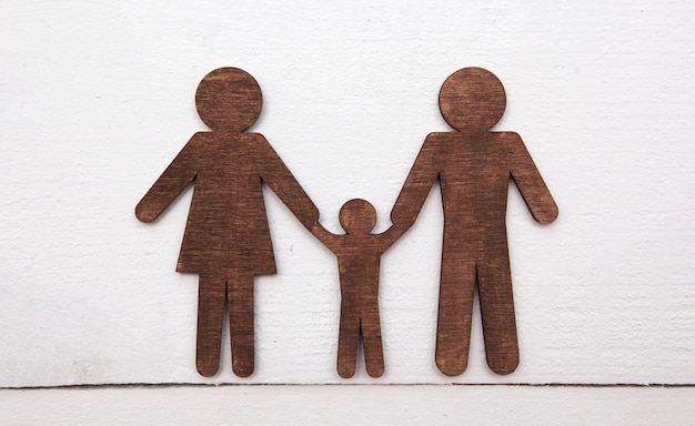 Statuettes en bois de mère, père et enfant sur plancher en bois