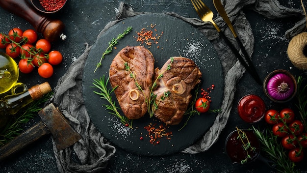 Steak d'agneau grillé aux épices et au romarin Viande barbecue Vue de dessus Vue de dessus à plat sur la table de coupe en pierre noire