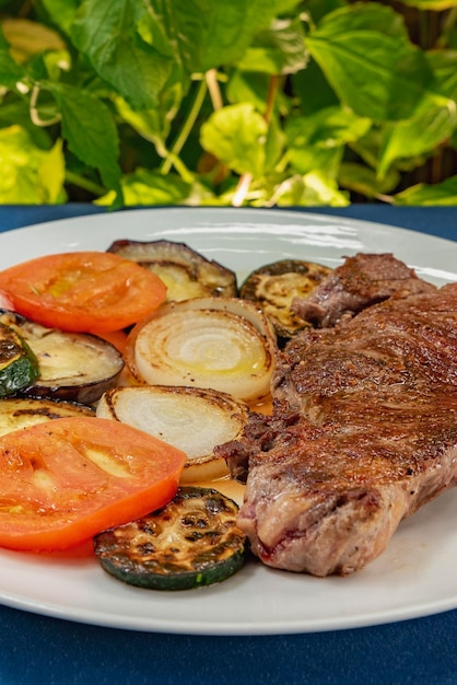 Steak sur une assiette avec photo verticale de légumes